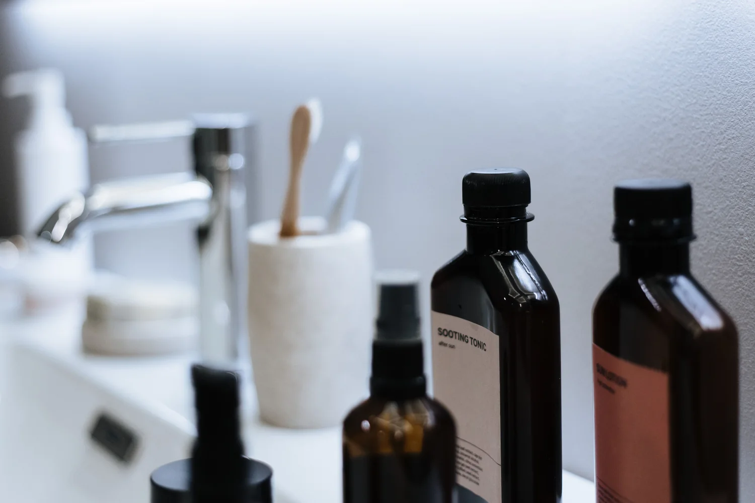 Beauty and personal care products on a clean bathroom vanity.