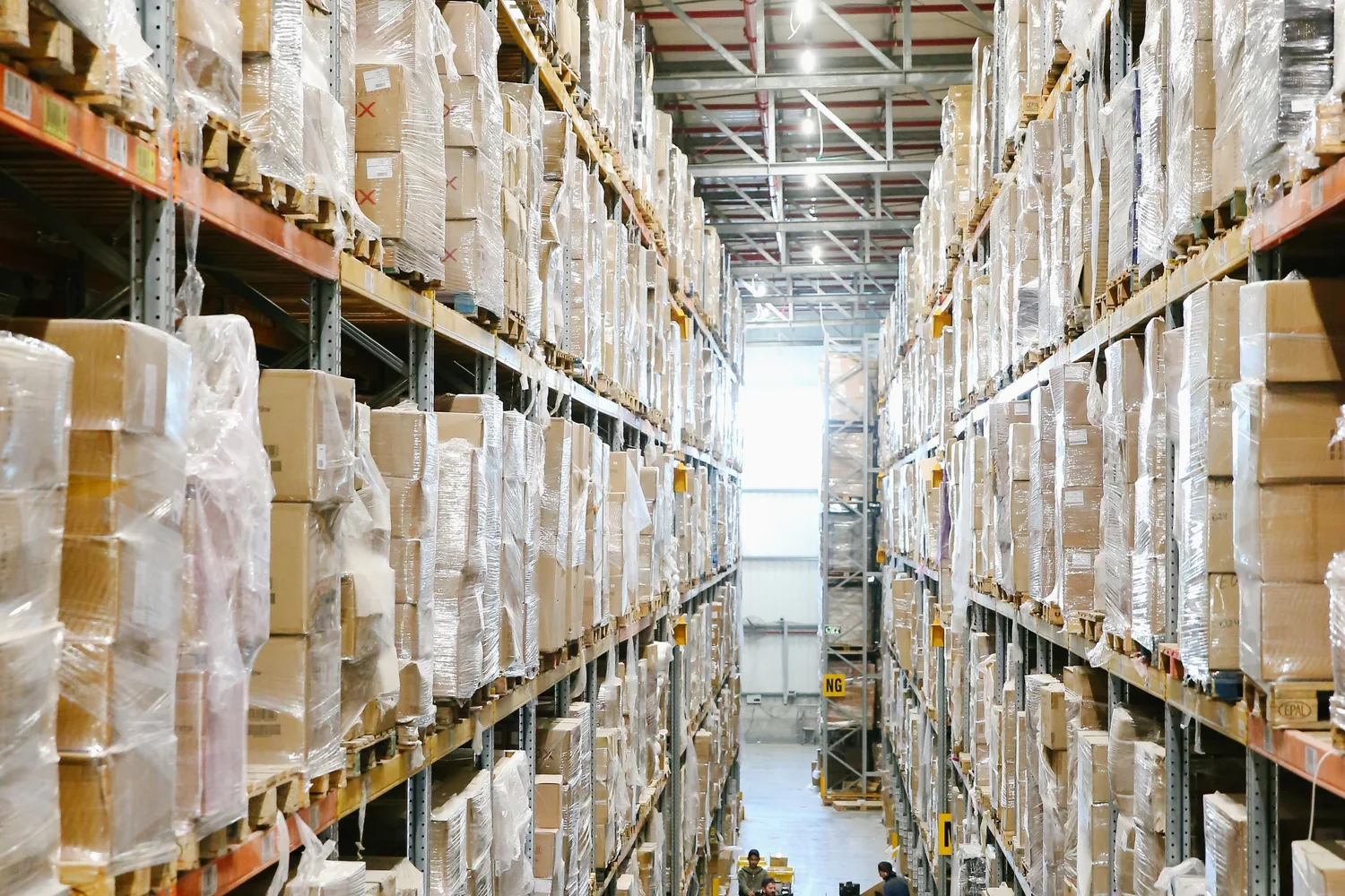 Organised boxed goods on shelves within a clean logistics environment.
